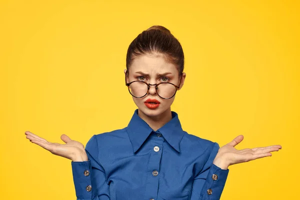 Een vrouw in een blauw shirt en bril met heldere make-up op haar gezicht is gebaren met haar handen Copy Space — Stockfoto