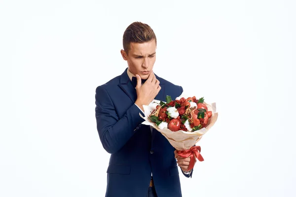 En elegant man i klassisk kostym med fluga håller en bukett blommor i handen — Stockfoto