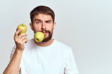 Elmalı, sağlıklı vitaminli, diyetli ve beyaz tişörtlü enerjik bir adam.