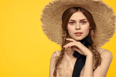 Sarı arka planda kırmızı örgülü kadın portresi.