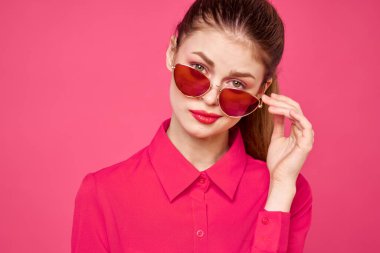 Pembe gömlekli ve kahverengi gözlüklü kadın kırpılmış görünüm modeli duyguları el hareketleriyle resim yapıyor.