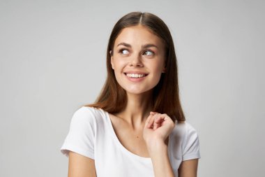 Mutlu kadın gülümsüyor ve arka planda yan tarafa bakıyor 