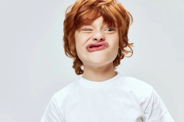 Rojo de pelo niño primer plano mueca cara labios estilo de vida recortado ver — Foto de Stock