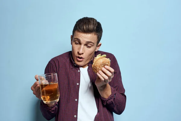 Vrolijk dronken man met bier mok en hamburger in de hand dieet voedsel levensstijl blauwe achtergrond — Stockfoto