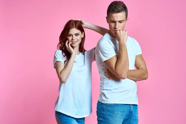 Amantes homem e mulher em jeans e t-shirt sobre rosa fundo recortado vista família romance adolescentes — Fotografia de Stock