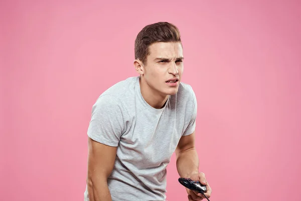 Homme gai avec joystick fil technologie divertissement style de vie rose fond — Photo