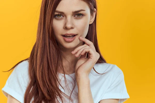 Mulher bonita em t-shirt branca cabelo longo glamour close-up fundo amarelo — Fotografia de Stock