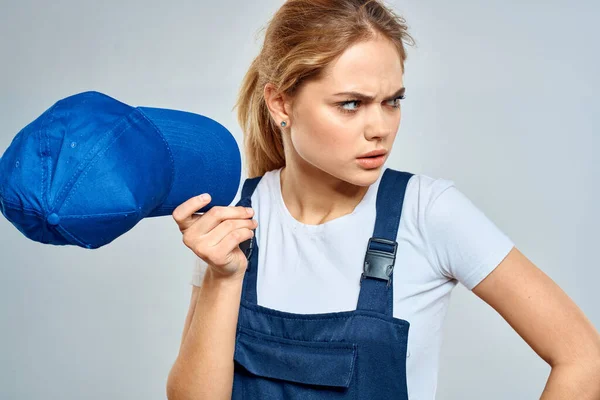 Frau in Arbeitsuniform blau Mütze Service Lieferservice Licht Hintergrund — Stockfoto