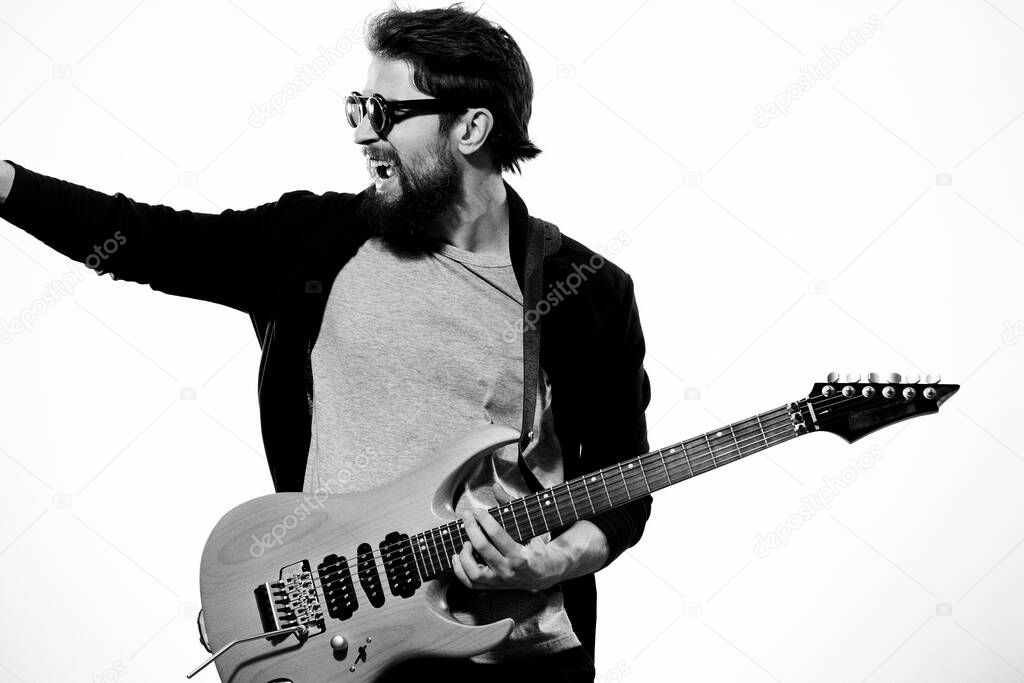 man with guitar in hands musician rock star performance lifestyle light background