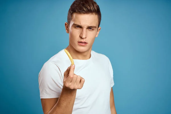 Man met frietjes in kartonnen plaat calorieën fast food blauw achtergrond tiener model bijgesneden uitzicht — Stockfoto