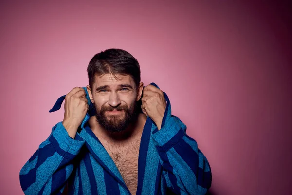 Homem barbudo em um manto listrado azul em um fundo rosa com as mãos emoções modelo retrato — Fotografia de Stock