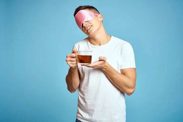 Homme avec masque de sommeil rose et tasse de thé boisson gaieté modèle petit déjeuner — Photo