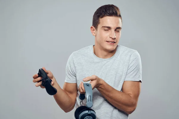 Hombre con auriculares y joystick en las manos tecnología entretenimiento videojuegos estilo de vida adicción luz fondo —  Fotos de Stock