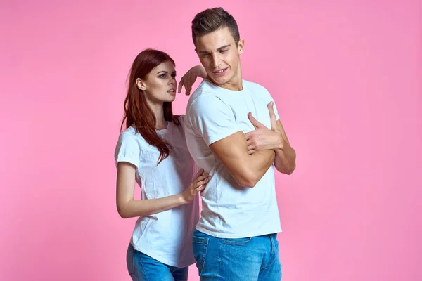 Amantes homem e mulher em jeans e t-shirt sobre rosa fundo recortado vista família romance adolescentes — Fotografia de Stock