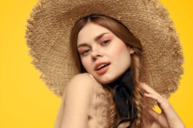 Sarı arka planda saman şapkalı portre kadın. Yazlık elbise mankeni romantizmi.