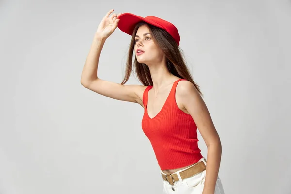 Kvinna tittar åt sidan rött lock och tank topp beskärd vy — Stockfoto