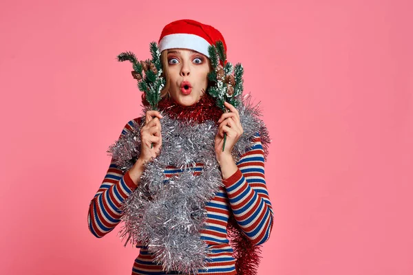 Femme avec des branches d'arbre de Noël dans les mains tinsel rouge et chapeau de fête rose fond vue recadrée — Photo