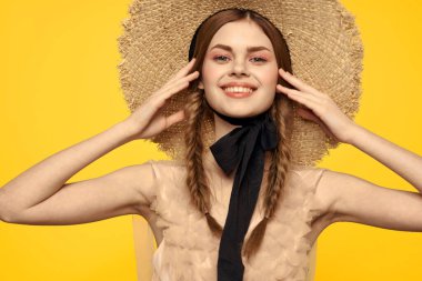 Sarı arka planda kırmızı örgülü kadın portresi.