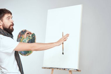 Erkek ressam, resim sehpası palet sanat yaratıcılığı ışık arka planında