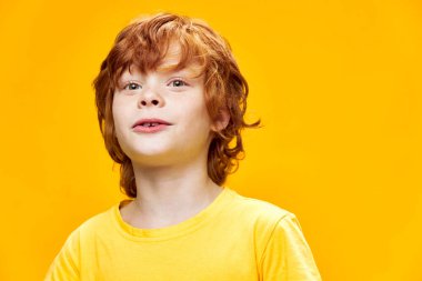 Sarı tişörtlü kızıl çocuk kendinden emin.
