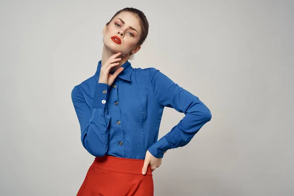 Una elegante dama de camisa azul hace gestos con las manos sobre un fondo claro y un retrato de primer plano — Foto de Stock