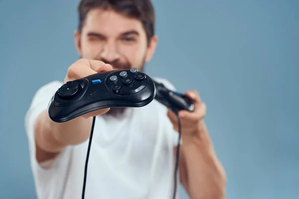 Hombre celebración gamepads juegos estilo de vida tecnología consola emociones blanco camiseta azul fondo —  Fotos de Stock