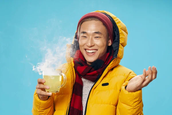 Forró ital citrommal és egy boldog sráccal meleg ruhában. — Stock Fotó