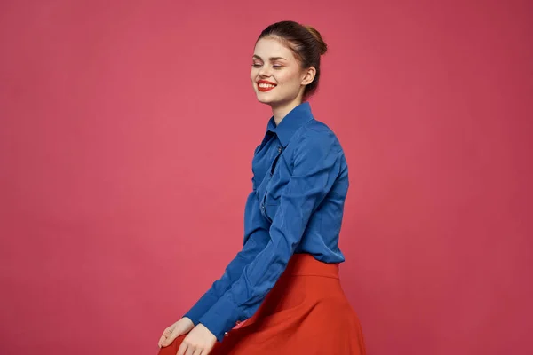 Mujer en camisa azul y cubos rojos sobre fondo rosa emociones divertidas modelo recortado ver — Foto de Stock