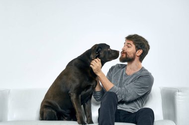 Kanepede evcil köpeği olan bir adam. Arkadaşlarıyla eğleniyor.