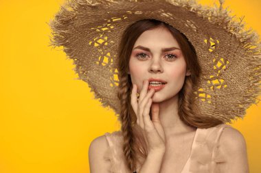 Şapkalı ve elbiseli bir bayan. Kızıl saçlı, sarı arka planlı, model portresi eğlenceli.