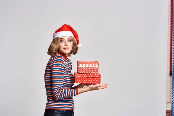 Щаслива жінка з різдвяними подарунками в руках і червоним капелюхом на голові новорічні свята обрізаний вид — стокове фото