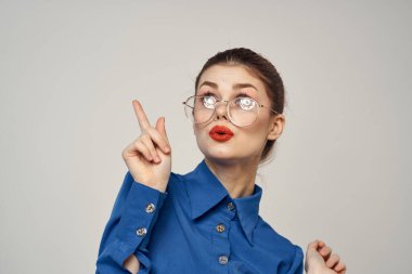 Mavi gömlekli ve gözlüklü duygusal kadın portresi parlak makyaj modeli arka plan kırpılmış görünüm kopyala