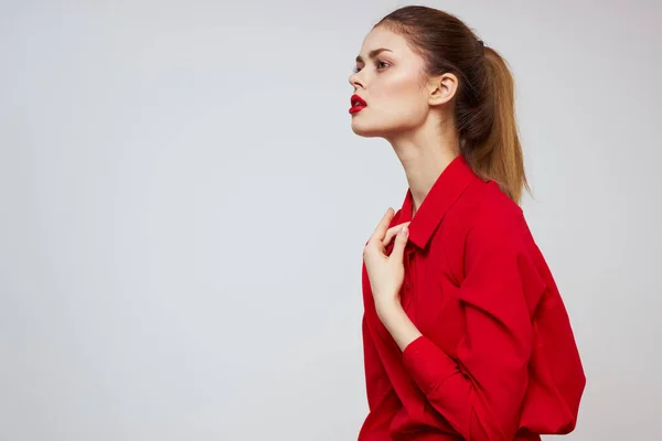 Een mooi meisje met rode lippen en een shirt op een lichte achtergrond gebaren met haar handen — Stockfoto