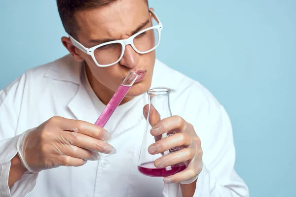 Homme tenant des flacons coloré liquide chimique modèle de laboratoire portant des lunettes — Photo