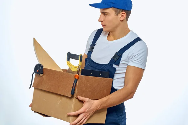 Ein Mann in Arbeitsuniform mit einem Karton in der Hand belädt einen Lieferdienst — Stockfoto