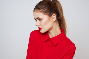 Açık arkaplanda kırmızı dudaklı bir kadının portresi. Makyaj modeli.