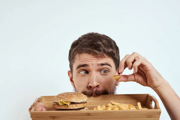 Mann mit hölzernen Tablett Pommes frites und Hamburger Fast Food Kalorien Modell weißes T-Shirt — Stockfoto