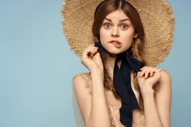 Gri arka planda hasır şapkalı romantik bir kız ve bej renkli bir elbise siyah kurdele duygu modeli.