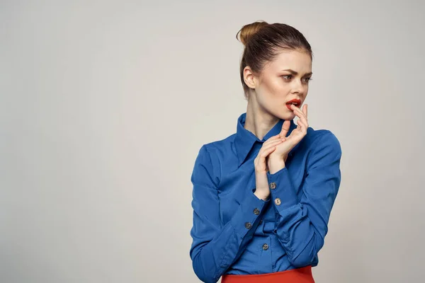 Uma senhora elegante em uma camisa azul está gesticulando com as mãos em um fundo leve e um espaço de cópia close-up retrato — Fotografia de Stock