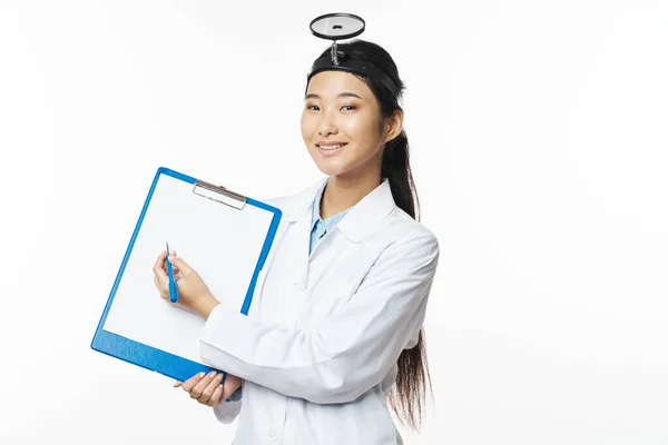 Žena lékař v lékařských šatech dokumenty v ruce a vyšetřovací nástroj — Stock fotografie