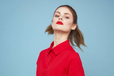 Mavi arka planda parlak elbiseli çekici bir kadın elleri ve kırmızı dudaklarıyla jestler yapıyordu.