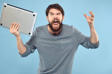 Sakallı adam dizüstü bilgisayarı elinde internet kablosuz teknoloji duyguları mavi arka plan