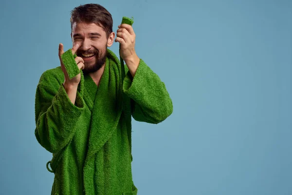 Бородатый мужчина в зеленом халате с поясом на синем фоне обрезанный вид эмоций — стоковое фото