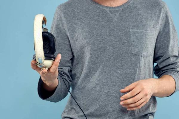 Słuchawki w rękach człowieka przycięte widok muzyka technologia niebieskie tło — Zdjęcie stockowe