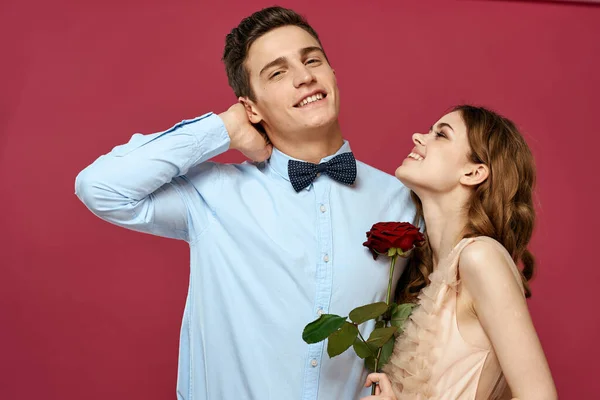 Portré romantikus pár szerelmes vörös rózsa elszigetelt háttér és klasszikus öltöny esti ruha — Stock Fotó