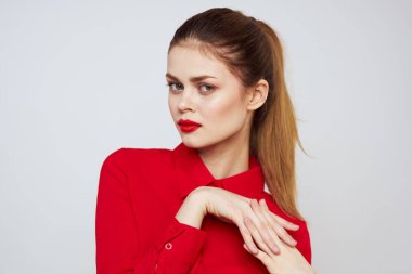 Açık arkaplanda kırmızı dudaklı bir kadının portresi. Makyaj modeli.