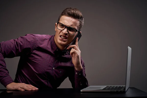 Manlig chef sitter vid bordet och talar på telefonen öppna laptop arbetsrum — Stockfoto