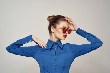 Güneş gözlüklü bir kadın portresi ve arka planda mavi bir gömlek. Model Kopya Boşluğu görünümü.