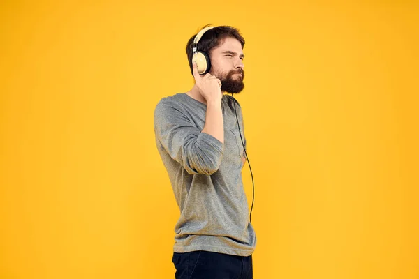 Hombre con auriculares música estilo de vida estilo de vida tecnología fondo amarillo —  Fotos de Stock
