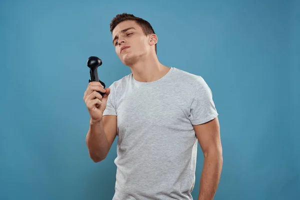 Um homem com um joystick em suas mãos entretenimento tecnologia de lazer videogames azul fundo branco t-shirt — Fotografia de Stock